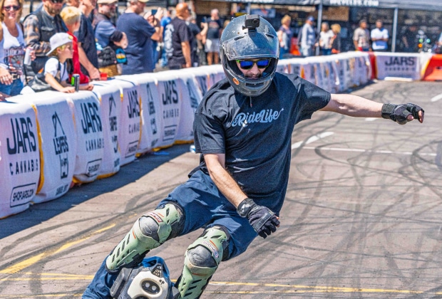 Amped Electric Rider Leaning Into A High-Speed Turn On An Electric Unicycle During A Live Event