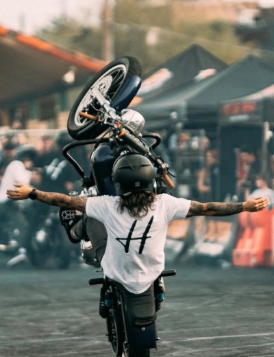 Danny Quick Performing A No-Hands Vertical Motorcycle Wheelie At A Live Stunt Show Performance