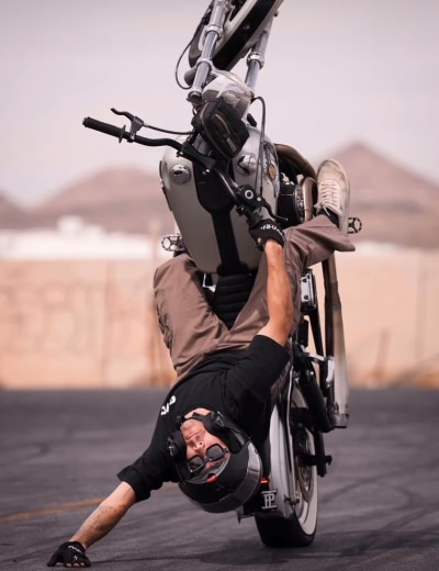 Zack Williams Performing A Vertical Motorcycle Wheelie And Head-Drag Stunt At A Live Show
